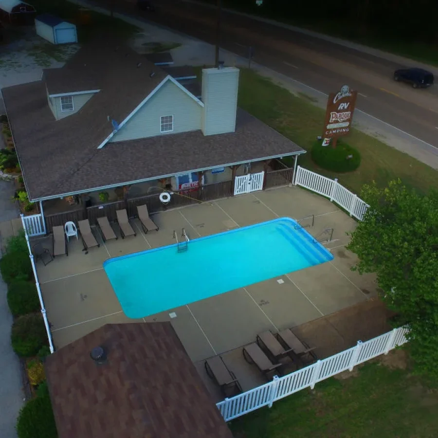 Aerial view of an outdoor swimming pool surrounded by parked RVs at Cahokia RV Parque